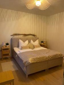 Schlafzimmer mit einem Bett mit weißer Bettwäsche und Kissen in der Unterkunft Haus am See in Malchow