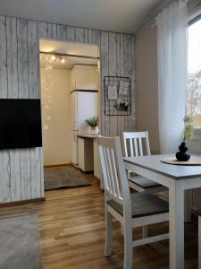 cocina y comedor con mesa blanca y sillas en Hilla Apartments en Rovaniemi
