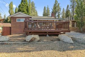 a house with a deck with two rocks in front of it at Base Camp New Ski Slope Views with HOT TUB. in Big Bear Lake