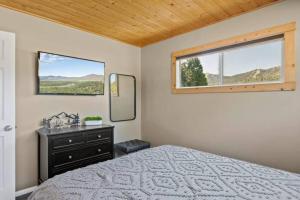 a bedroom with a bed and a mirror and a window at Base Camp New Ski Slope Views with HOT TUB. in Big Bear Lake