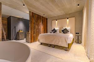 a bedroom with a large bed and a bath tub at Villa Jura, l’écrin à pied entre village et pistes in Foncine-le-Haut +41 photos