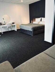 een slaapkamer met een bed en een bureau met een spiegel bij Firstclass Event & Hotel in Fürth