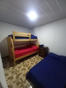 Habitación pequeña con 2 camas y mesita de noche en Apartahotel Los Ángeles en Cartagena de Indias