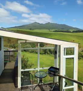 a view from the deck of a house with a table and chairs at Raglan's Tranquil Garden Retreat - Moa Stone Lodge in Raglan