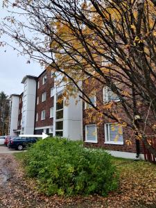 un edificio de ladrillo con un árbol delante de él en Hilla Apartments en Rovaniemi