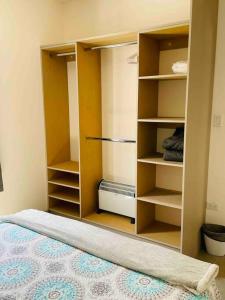 Cette chambre comprend un placard avec des étagères et un lit. dans l'établissement Gabby’s Accesible House in Private area, à Mexicali
