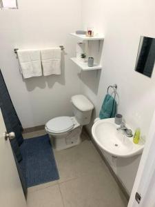 a white bathroom with a toilet and a sink at Gabby’s Accesible House in Private area in Mexicali