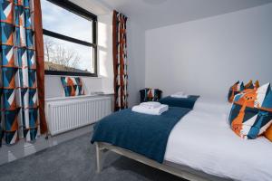 a bedroom with two beds and a window at New 4 Bedroom Home at Waterhead Range by LetMeStay in Ambleside