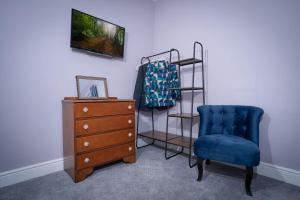 a room with a blue chair and a dresser at New 4 Bedroom Home at Waterhead Range by LetMeStay in Ambleside