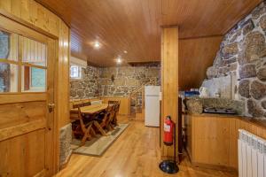 a kitchen and dining room with a stone wall at Casinhas das Tílias in Seia