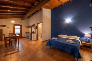 a bedroom with a bed and a table and a kitchen at Agriturismo di Sordiglio in Casina