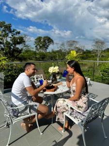 un homme et une femme assis à une table dans l'établissement Casa Merchu Finca Spa, à Puerto Espejo