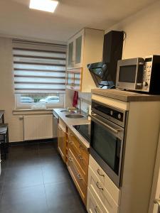 eine Küche mit einem Kochfeld, einem Backofen und einer Mikrowelle in der Unterkunft Meli-Vellmar in Vellmar