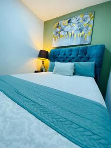 a bedroom with a large bed with a blue headboard at Suite independiente en ciudadela privada in Guayaquil