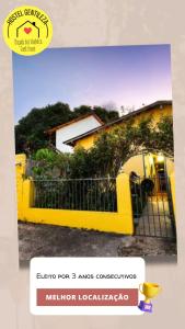 a yellow fence in front of a house at Hostel Gentileza - Guest House in Alto Paraíso de Goiás