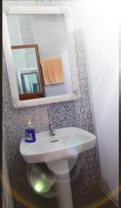 ein Badezimmer mit einem weißen Waschbecken und einem Spiegel in der Unterkunft Dar messiar in Chefchaouen