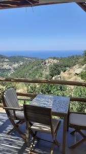a table and chairs on a deck with a view at Monopati Eco Villas in Raches
