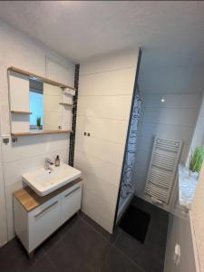 ein Bad mit einem Waschbecken und einem Spiegel in der Unterkunft Meli-Vellmar in Vellmar