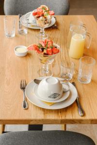 una mesa con platos de comida y un bol de fruta en B&B Logie Jolie, en Ypres