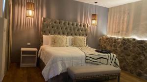um quarto com uma cama grande e uma grande cabeceira. em Altamonte Hotel Boutique em Bernal