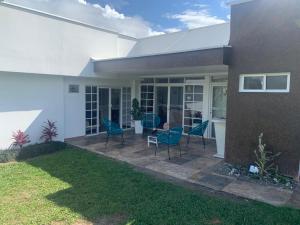 Casa con sillas azules y patio en Casa Merchu Finca Spa, en Puerto Espejo