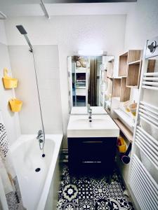 a bathroom with a white sink and a tub and a tub at Appart 5pers joue du loup pied de pistes vue top in La Joue du Loup