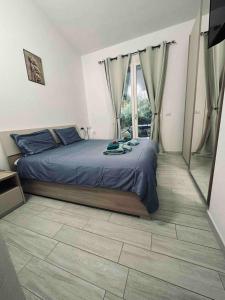 - une chambre avec un lit et une grande fenêtre dans l'établissement Magnifique villa neuve en bord de mer, à Sassari