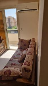a bed in a room with pillows on it at Gardenia City cairo airport in Cairo