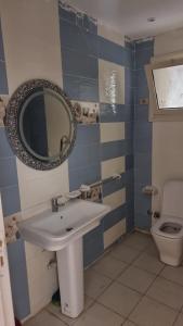 a bathroom with a sink and a mirror and a toilet at Gardenia City cairo airport in Cairo