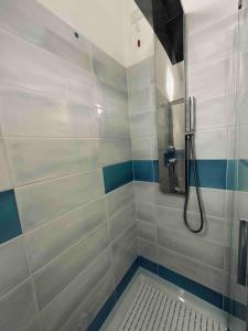 bagno con doccia e piastrelle bianche e blu di Magnifique villa neuve en bord de mer a Sassari