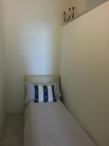 a small bedroom with a bed with blue and white pillows at Appartamento Trento Trieste in Sanremo