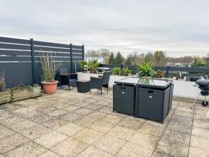 a patio with tables and chairs on a roof at Le Roof Top - Parc des Expos - Roissy CDG in Villepinte