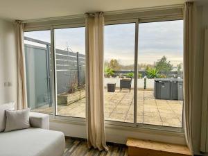 a bedroom with a large window with a view of a patio at Le Roof Top - Parc des Expos - Roissy CDG in Villepinte