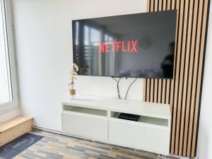 a tv sitting on top of a white entertainment center at Le Roof Top - Parc des Expos - Roissy CDG in Villepinte