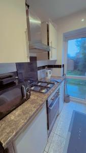 a kitchen with a sink and a stove top oven at Cozy Room in London in Plumstead