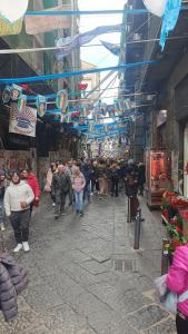 Eine Gruppe von Menschen, die eine Straße auf einem Markt entlanggehen in der Unterkunft Affittacamere Nilo in Neapel + 14 Fotos