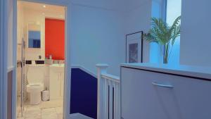a blue bathroom with a toilet and a sink at Cozy Room in London in Plumstead
