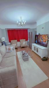 a living room with a couch and a flat screen tv at Cozy Room in London in Plumstead