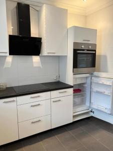 uma cozinha com armários brancos e um forno com placa de fogão em JQ Apartments Prime em Acra