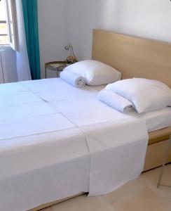2 łóżka z białą pościelą i poduszkami w pokoju w obiekcie Endoume mon amour w Marsylii