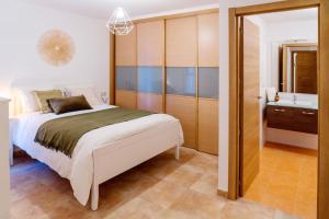 a bedroom with a large bed and a bathroom at Apartamento Catuxa in Malpica