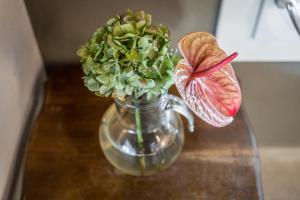um vaso de vidro com flores e uma borboleta sobre uma mesa em La Casa di Valeria - Modena em Modena