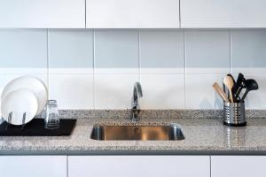 a kitchen with a sink and a counter top at Apartamento Catuxa in Malpica +31 photos