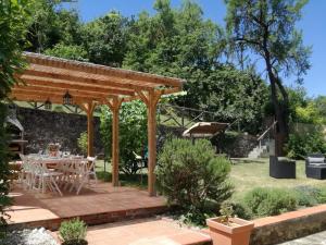 a wooden pergola in a garden with a table and chairs at Chianti Best House in Greve in Chianti
