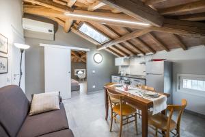 cocina y sala de estar con mesa y sillas en La Casa di Valeria - Modena, en Módena