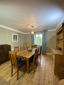 Un comedor con mesa y sillas de madera. en Brittany Carantec Morlaix, en Saint-Martin-des-Champs