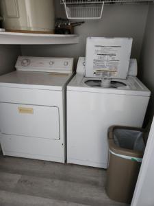 una lavadora y secadora sentadas junto a un cubo de basura en Tropical Haven, en Panama City Beach