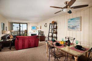 a living room with a red couch and a table at Oceanfront condo at North Coast Village in Oceanside