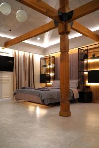 1 dormitorio con 1 cama grande y vigas de madera en Bansko Nest, en Bansko