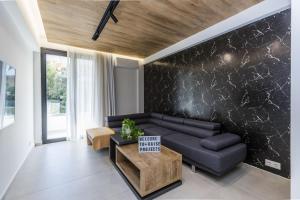 a living room with a couch and a table at Varkiza Luxury Suites by Raise in Vari